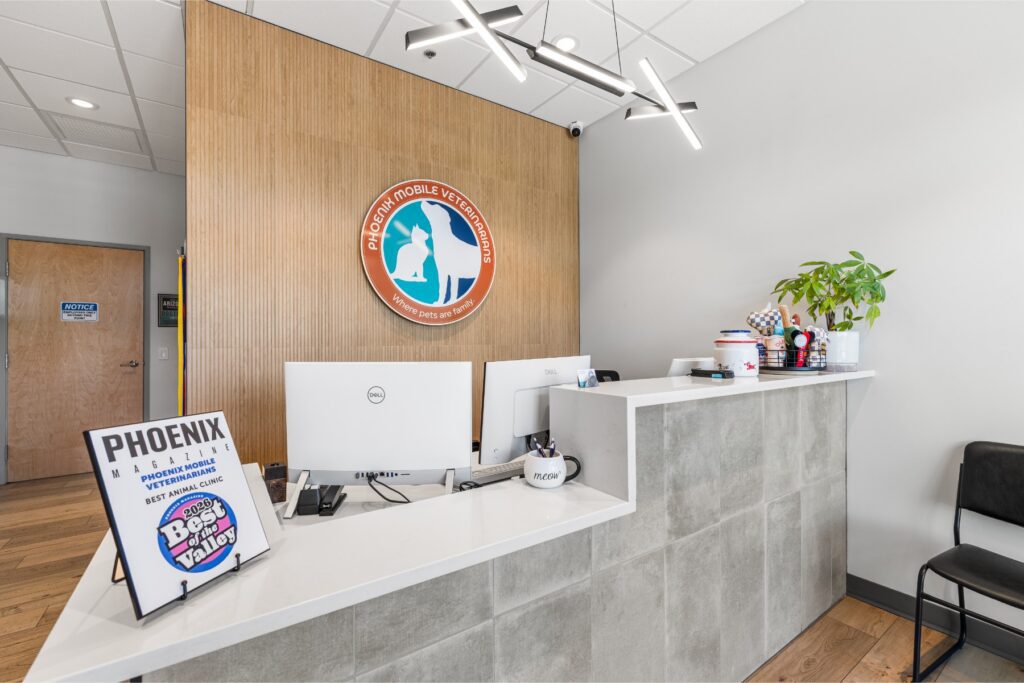 Front desk and Phoenix Mobile Veterinarians wall logo inside the Scottsdale veterinary hospital